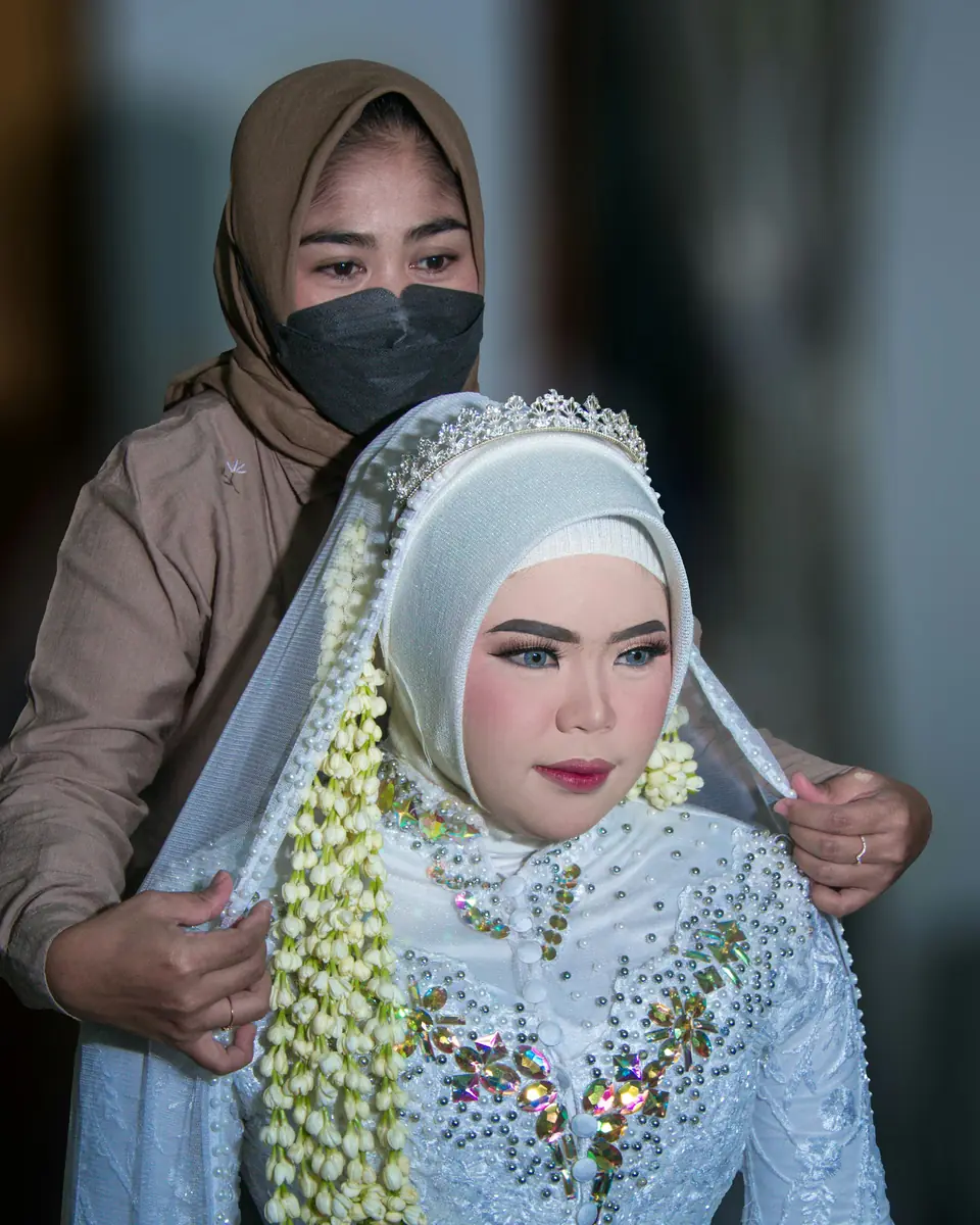 Make-up artist merapikan kerudung pengantin berhias ronce melati sebelum akad